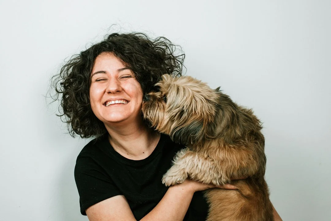 Pet parent laughing with her dog
