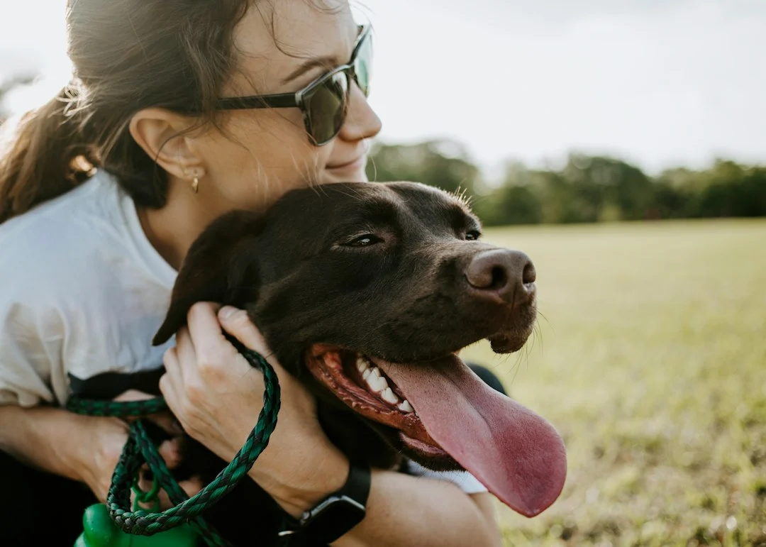 Happy pet owner lovingly hugging their dog