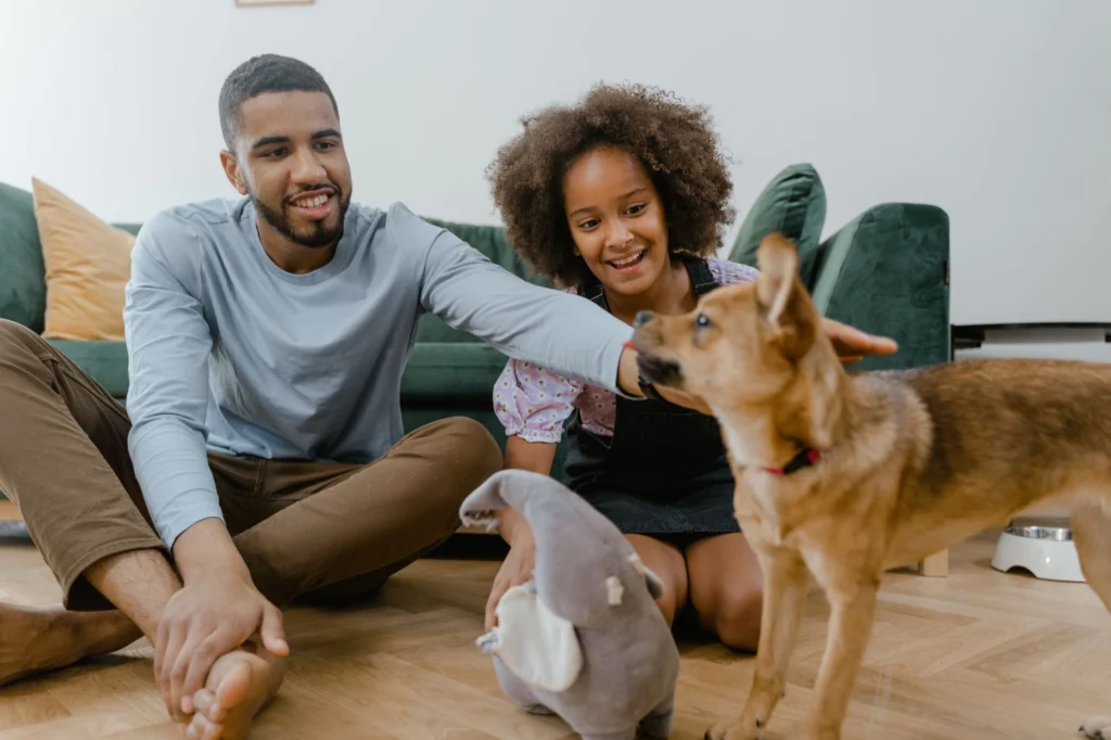 Family sitting on the floor at home with their two dogs